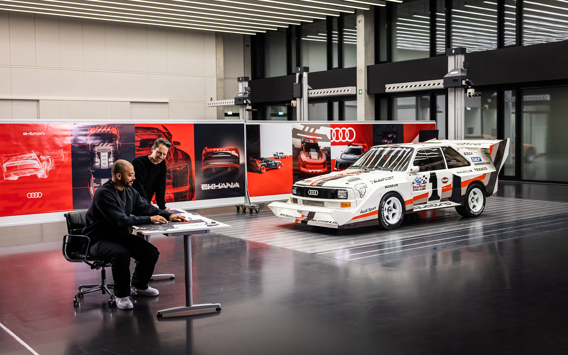 Les premières ébauches du designer Sascha Heyde (debout) ont donné sa forme à l'Audi S1 e-tron quattro Hoonitron¹. Le légendaire véhicule de rallye Audi Sport quattro S1 n'a pas seulement donné son nom au prototype de drift, il a également été un modèle pour Heyde et son équipe. Il fallait créer des ponts entre le passé et l'avenir au niveau des formes et des lignes.